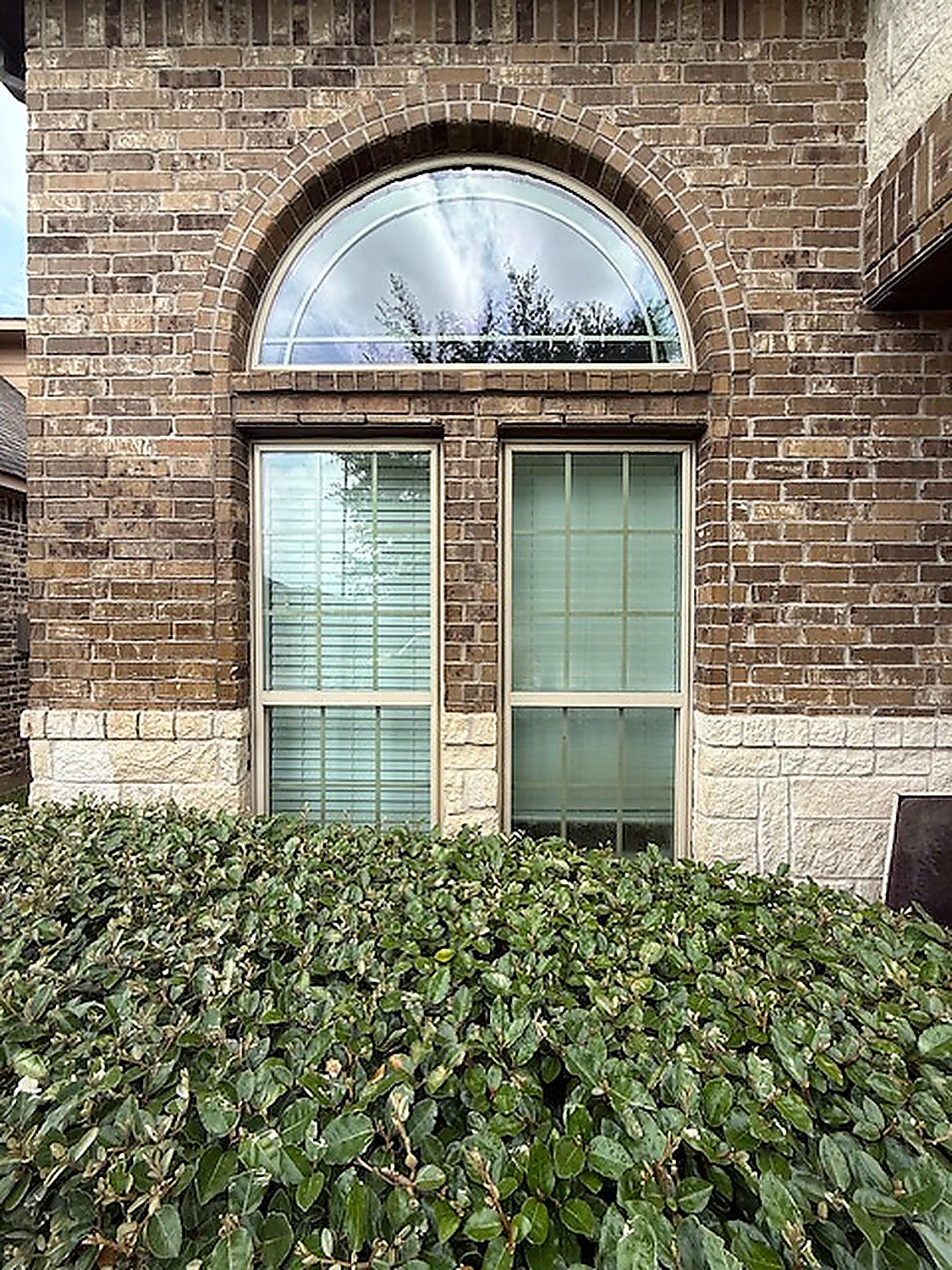 Arched window cleaning on brick home